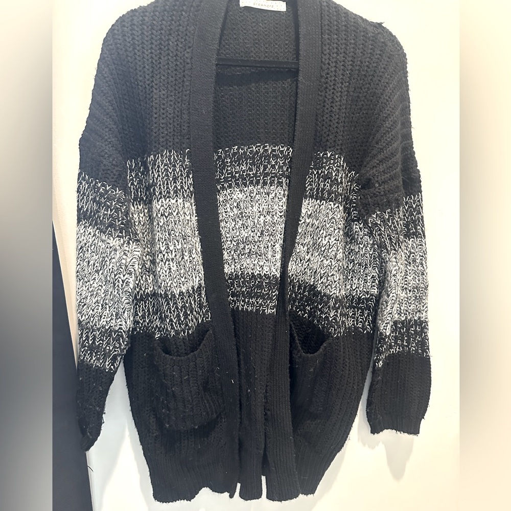 Sweater- black-and-white large knit cardigan, two front pockets.